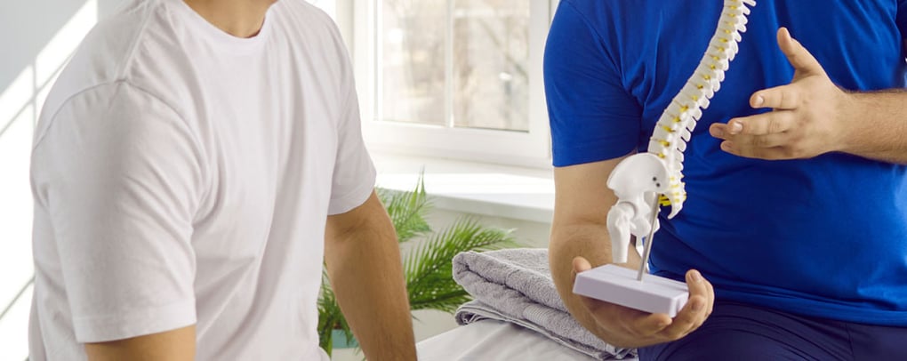 doctor showing spine model to patient