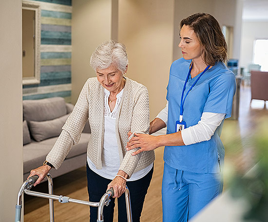 senior patient with a walker, nurse assisting 