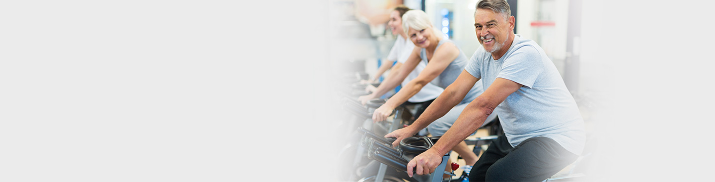 seniors and physical therapist exercising on bike