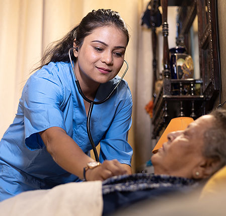 nurse checking on senior patient in bed