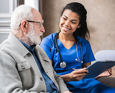 nurse with clipboard and patient discuss treatment