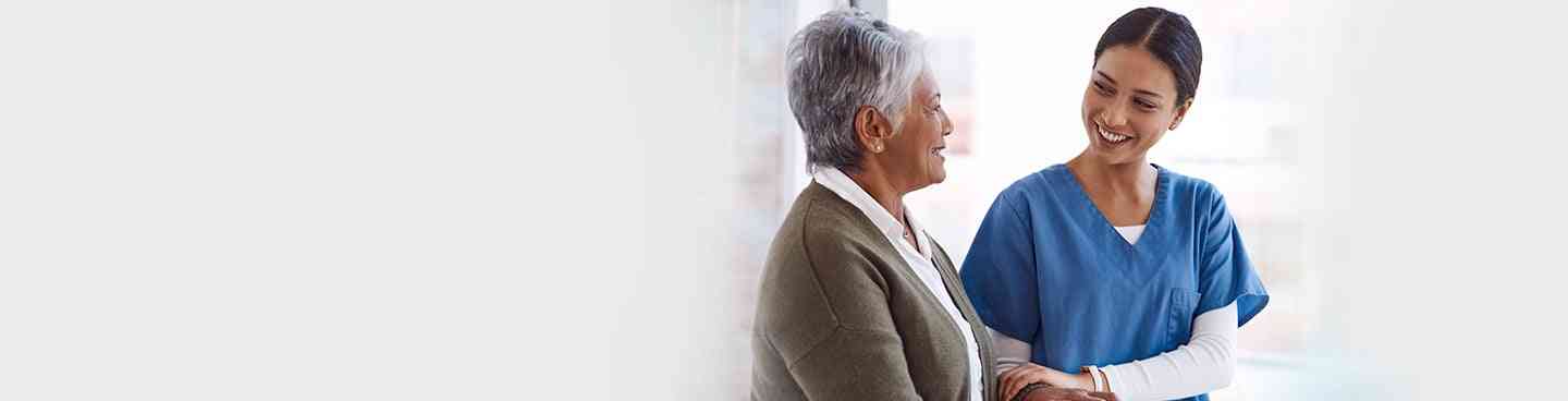 Nurse assisting elderly patient in walking