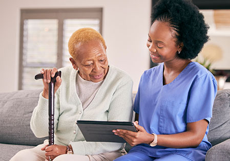 senior with nurse looking at tablet