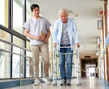 therapist walking with patient in a hallway