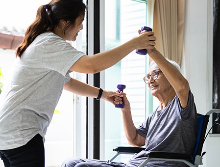 therapist assisting movement with patient in a wheelchair