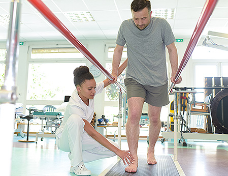 physical therapist assisting patient with walking