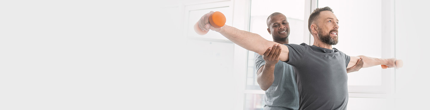 physical therapist helping patient with weights