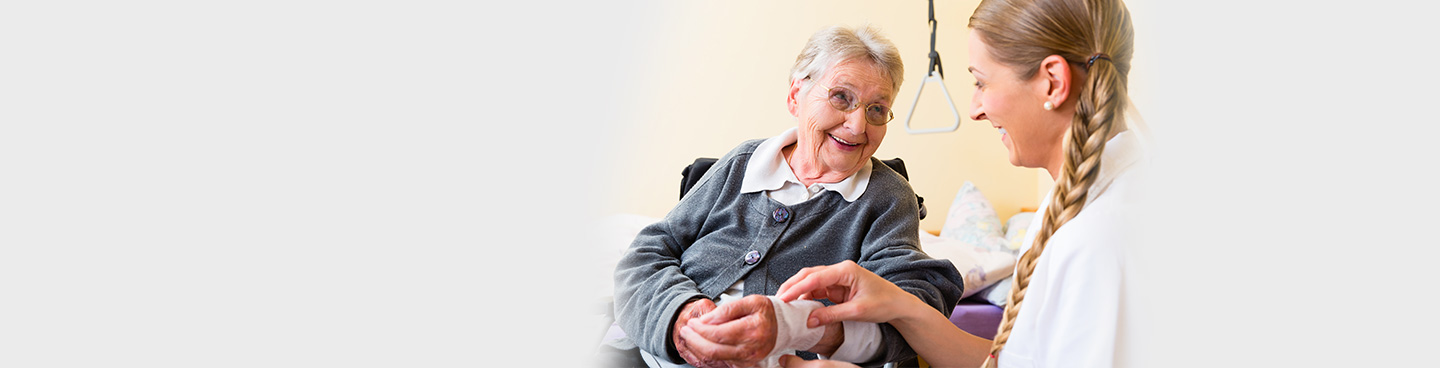 Nurse treating senior patient's wound